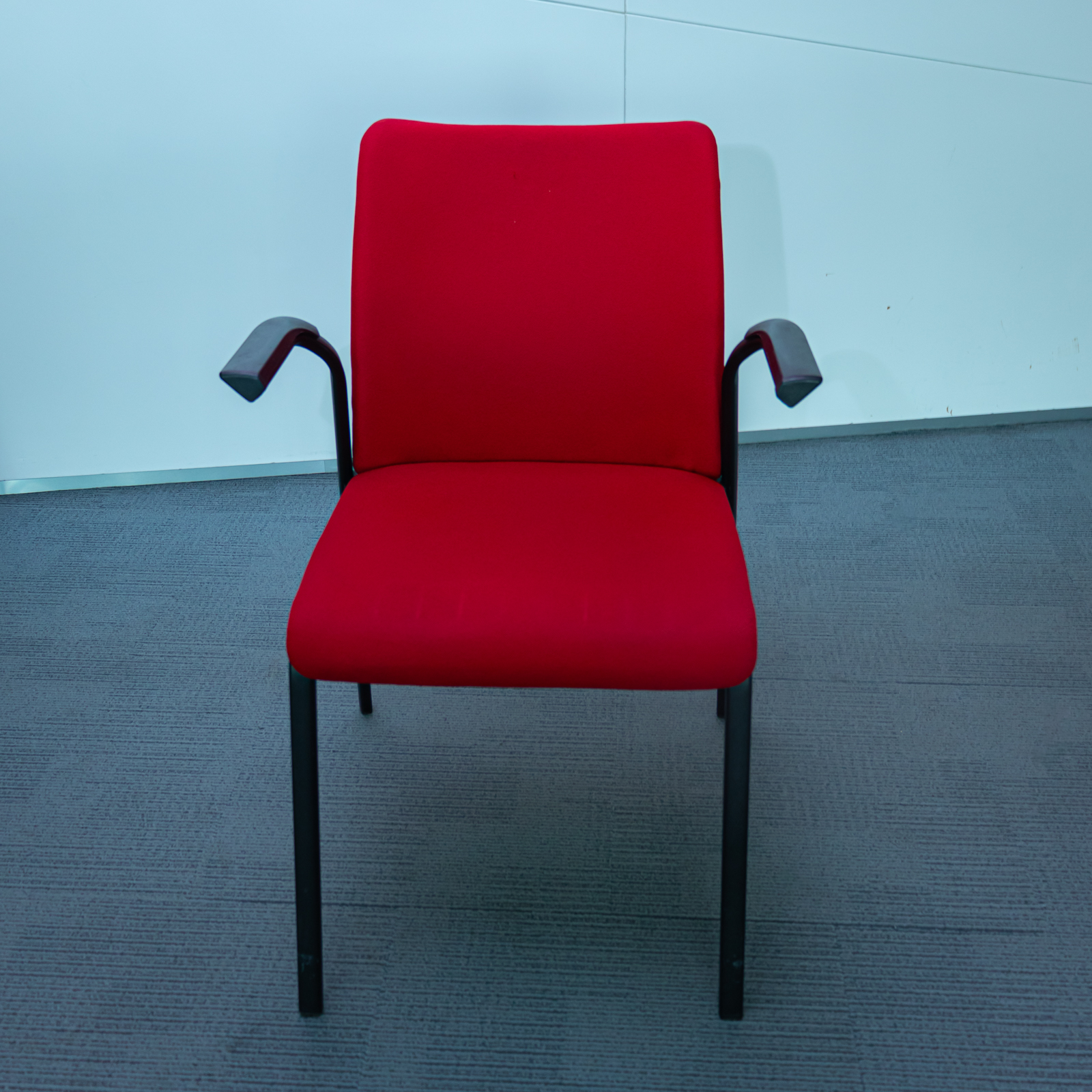 Silla tapizada roja con brazos y estructura metálica negra