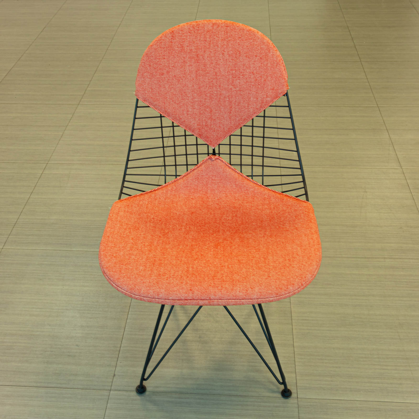 Silla salmón con base de varilla negra y cojines tapizados