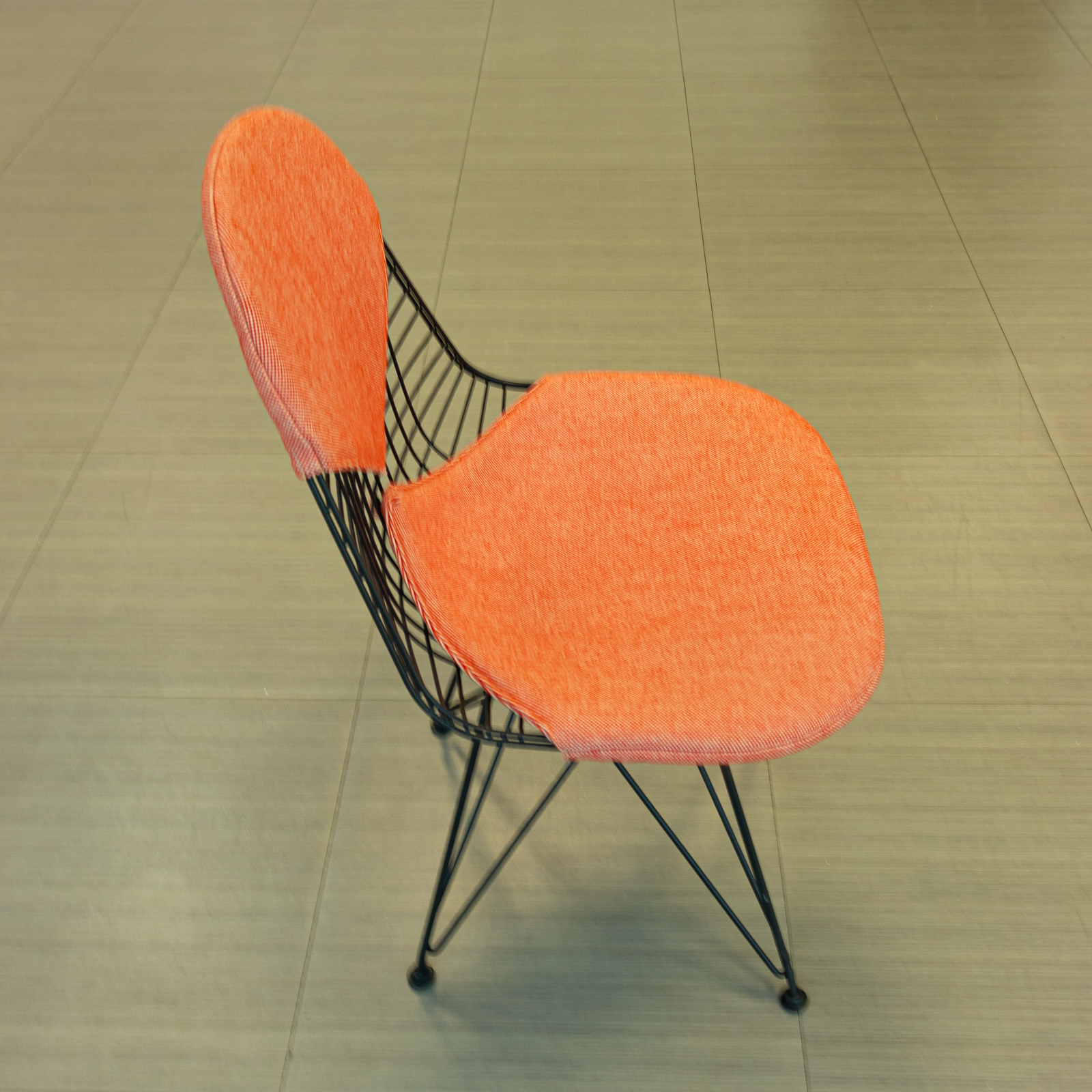Silla salmón con base de varilla negra y cojines tapizados