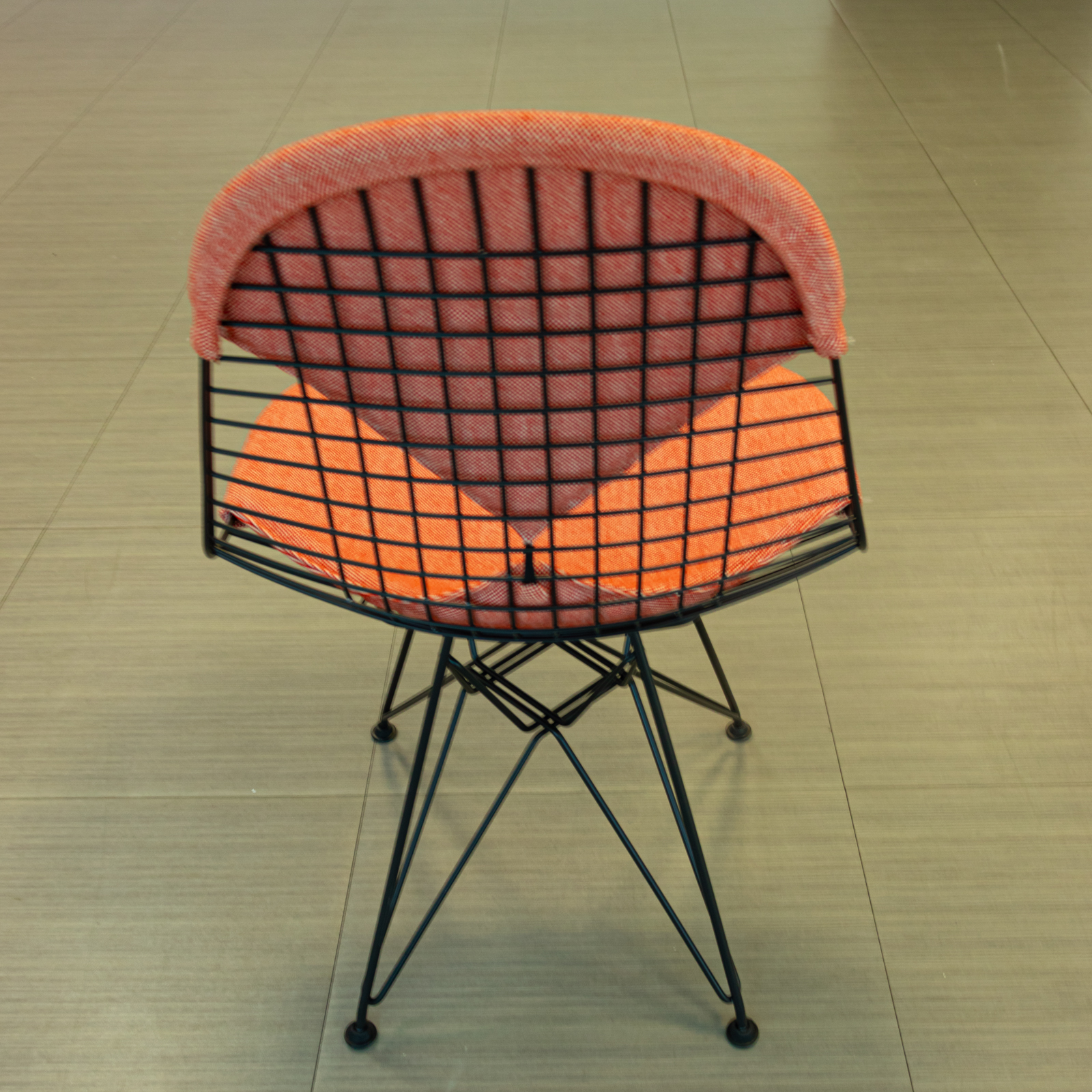 Silla salmón con base de varilla negra y cojines tapizados