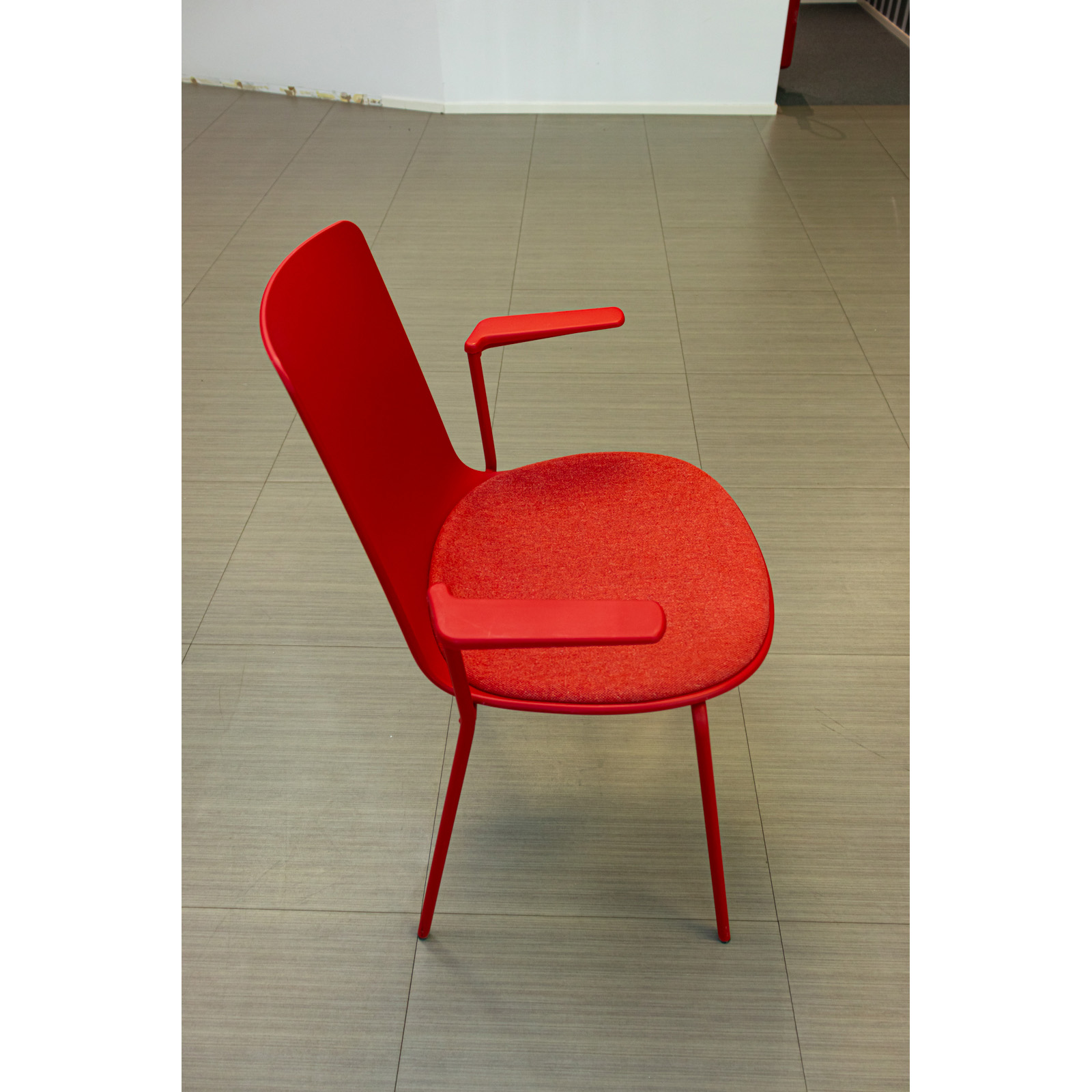 Silla tapizada roja con brazos integrados