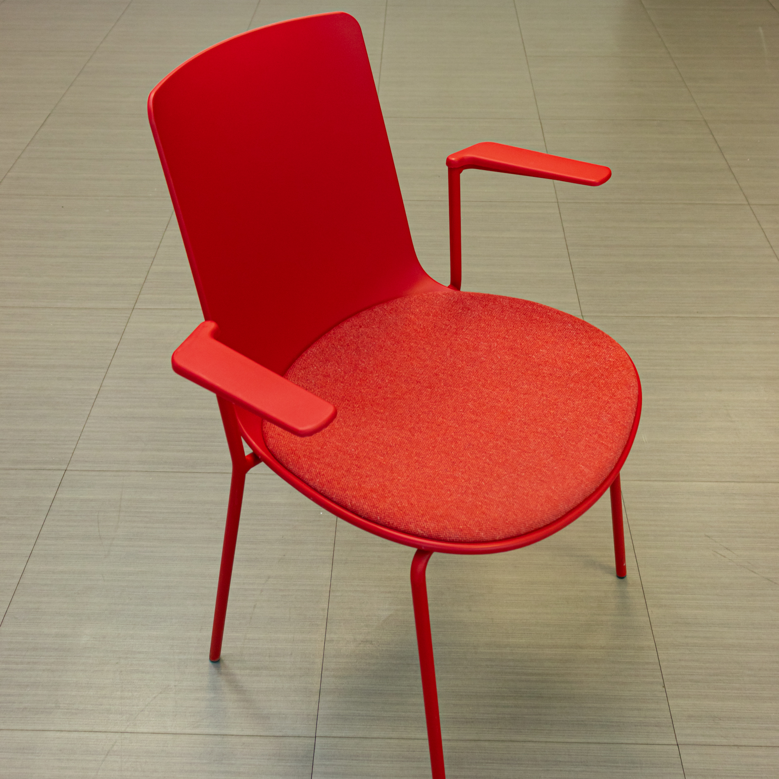 Silla tapizada roja con brazos integrados